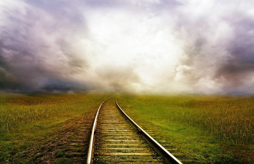 Un chemin de rail de train, se fond dans la brume.